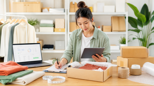 An online seller reviewing inventory and shipping details at a bright organized workspace